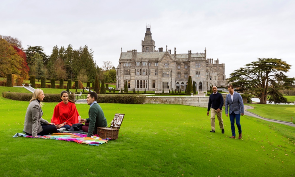 Reconnect in Ireland - Image here shows people picnicking and walking on the grounds of Adare Manor in Country Limerick. 