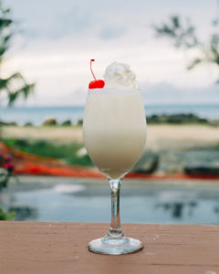 Image of single pina colada garnished with whipped cream and cherry. Photo courtesy of Visit Puerto Rico.