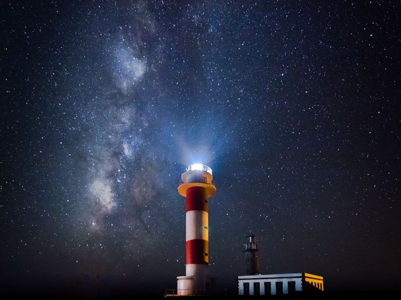 The island of La Palma, which has no light pollution, is one of the best places in the world for star gazing. Photo of La Palma's nightsky and the Faro de Fuencaliente is by Robert Steinert | Canva.